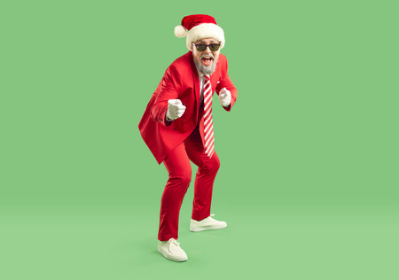 Full length shot of emotional fashionable Santa Claus in elegant red suit having fun and indicating at you, exclaiming loudly, choosing you to participate in New Year Party celebration.の写真素材