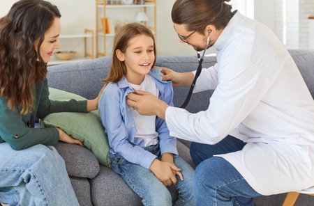 Friendly family pediatrician in medical coat stethoscope listening checking little boy breathing, specialist exams small cute patient at health check, pediatry, caring nurse, GP consultation at homeの写真素材