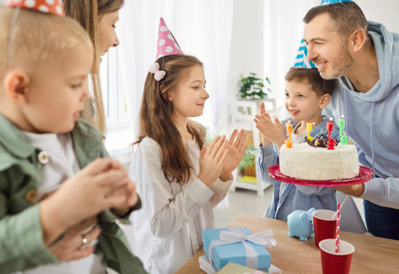 Happy birthday big family party with cake, overjoyed child girl getting birthday surprise gift from...