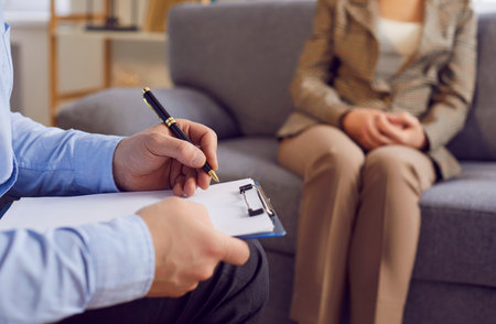 Psychiatrist, psychiatric doctor session for mental health professional help, writing form close up. Diagnosing and treating psychiatric disorders, discussing symptoms with patient woman on couchの写真素材