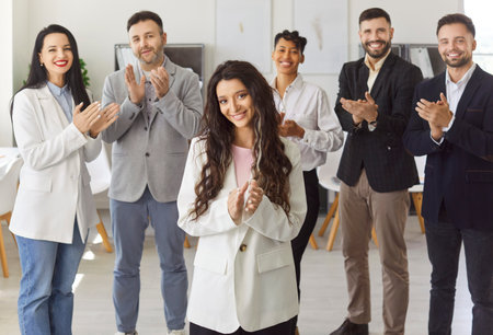 Happy diverse group of colleagues clapping, celebrating achievement, woman leader applauses to show success, collective happiness, appreciation, positive professional situation, team accomplishmentの写真素材