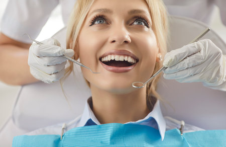 Doctor dentist examines patient oral care with dental instrument during clinic visit, providing rescue service in dentistry, focusing on health in a professional setting with attention.の写真素材