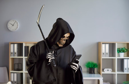 Grim reaper in devil mask with scythe uses phone for online and internet activity in office,...