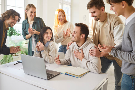 Group of happy smiling young college or university students sitting at the desk in the classroom...