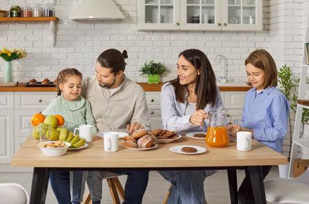 Portrait of happy family of father, mother and kids gathering in kitchen at home together having a...