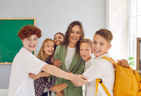 Portrait of a happy schoolchildren group with backpacks standing with their female friendly teacher...