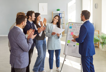 Business people applauding during a work meeting or presentation in an office. A professional team...