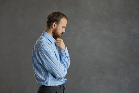 Pensive adult caucasian business man, executive manager, freelancer or company leader touching beard...