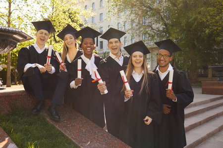 Portrait of a group smiling laughing happy multiracial international graduates students standing in...