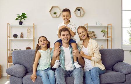 Happy family of four having fun at home. Portrait of cheerful, joyful, beautiful parents and...
