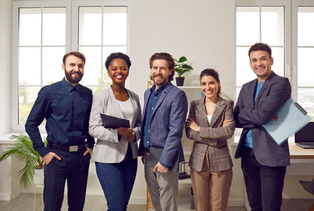 Portrait of happy confident and successful multiracial business team posing in office. Smiling men...