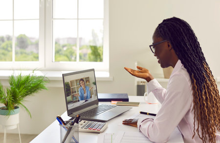 Two diverse business women having an online work meeting via a video call. African American lady...