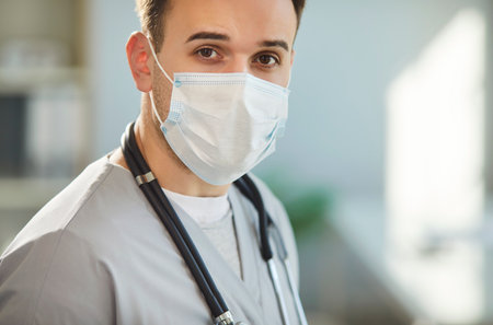 Physician, surgeon doctor, serious male nurse medical professional looking, wearing face mask,...