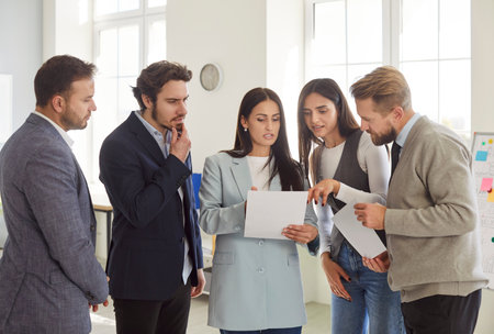 Group of business people doing paperwork together in office room negotiating a new contract focused...