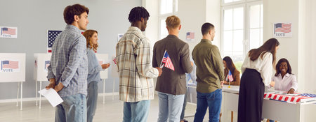 Large group of diverse people registering at polling station holding American flags in hands on...