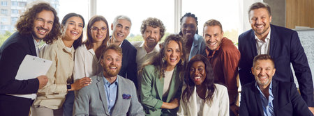 Happy team at business event or work meeting in office. Group portrait of cheerful diverse young and mature people smiling and looking at camera all together. Banner. Business conceptの写真素材