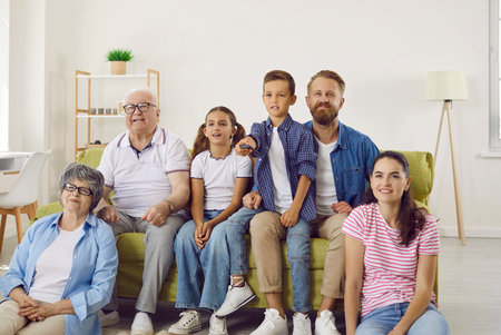 Cheerful multi-age big family watching TV together and enjoying spending time together....