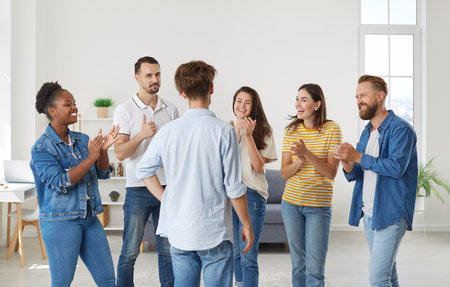 Joyful enthusiastic friends applaud man expressing their respect and congratulating him on victory....