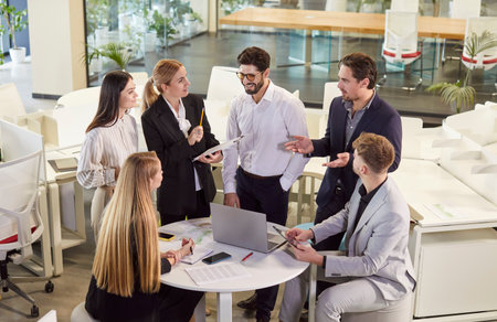 Young confident people group of company employees talking on business meeting sitting in modern office during a conference, discussing new job projects or startups. Teamwork concept.の写真素材