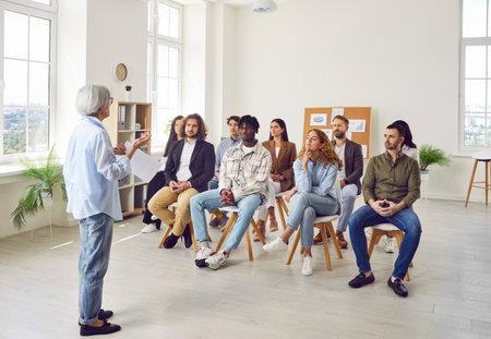 Group of diverse business people on meeting discussing work project sitting in a row in office....