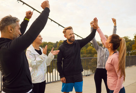 Togetherness and teamwork of group of friends in sport comes together for outdoor workout giving...