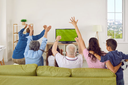 Three family generations watching football together. Happy parents, children, senior grandma and...