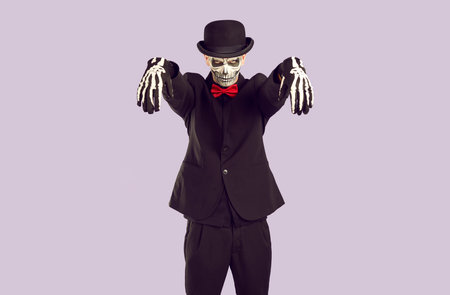 Skeleton man in Halloween costume looks ominously at you while standing in zombie pose. Young man...