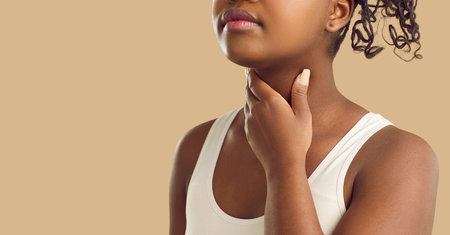 Young sick woman suffers from sore throat, tonsillitis, painful swallowing or loss of voice. Close...