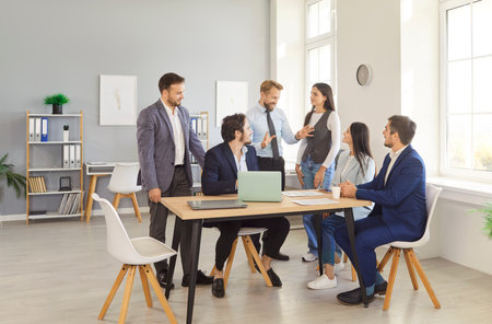 Young confident people group of company employees talking on business meeting sitting in modern...