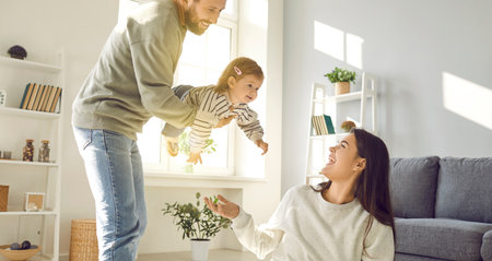 Family spending time at home with their daughter. Young Caucasian parents are playing and having fun...
