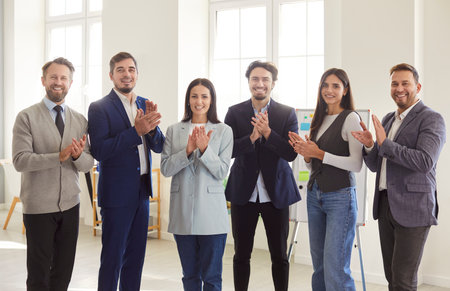 Group of confident happy business people men and women looking cheerful at camera, smiling and...