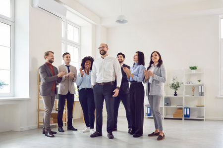 Confident happy business man and multicultural team. A group of business people applaud a colleague....