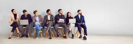 Business people sitting in row looking to side. Male and female job candidates in foemal wear sitting on chairs waiting for job interview in office. Employment, human resource conceptの写真素材