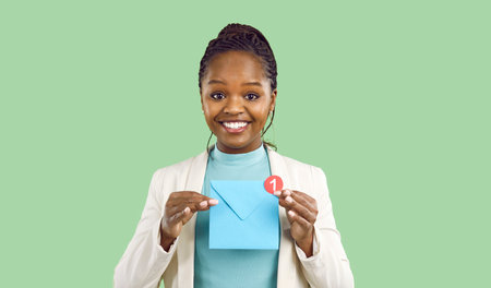 Portrait of smiling young African American woman hold paper envelope with unread notification. Happy...