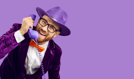 Banner of smiling man in party suit talk on landline phone with client or customer. Happy showman or performer in disco costume have pleasant on corded telephone. Communication.の写真素材