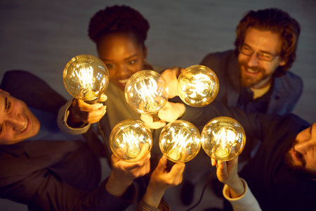 Team work. Bright glowing light bulbs in hands of various people as symbol of new creative ideas....