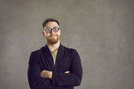 Studio shot of happy nerd. Portrait of funny guy isolated on grey text copy space background....