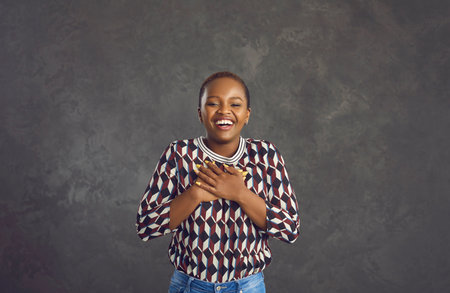 Thank you from bottom of my heart. Happy charming black woman smiling, laughing, holding hands on...