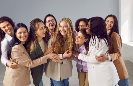Group portrait of happy diverse women hugging and looking at camera. Team of cheerful, joyful, beautiful, young, diverse, mixed race pretty business ladies meeting and having fun all togetherの写真素材