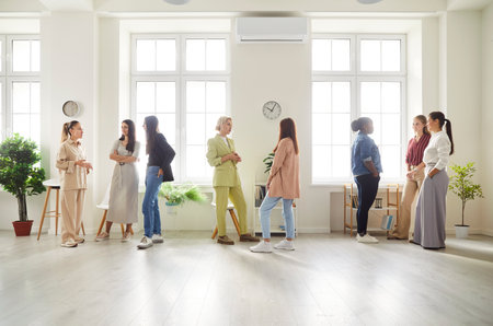 Team of women engages in a business conversation during a meeting in the office, fostering teamwork, collaboration, and diverse ideas among people working together toward common goals.の写真素材