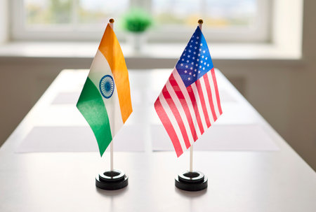 Flags signal diplomacy, meeting and negotiation at table. India and USA flags signal bilateral discussion and international agreement. Symbolic concept: diplomatic cooperation and partnership.の写真素材