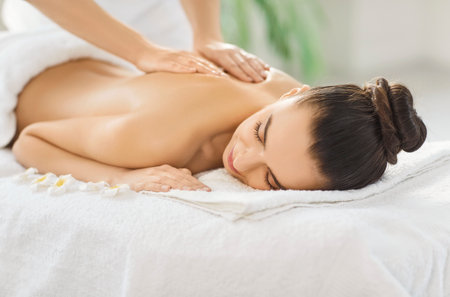 Woman enjoys resting relaxing aromatics massage oil pleasure, stimulating skin health, massage therapist doing back massage, spa shoulder, back care, relax muscles, energising body, beauty treatmentの写真素材