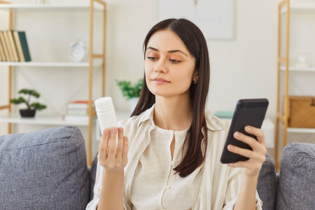 Woman searching information about pills in internet, reading instruction about medicaments prescribed by doctor, exploring treatment options, seeking for medical advice. Health care researchの写真素材