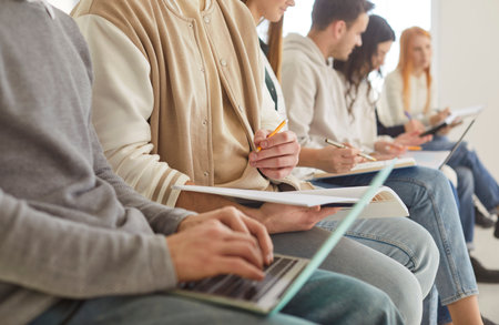 Business people or students working and learning together in office, using laptops and documents, team collaboration, creating an educational atmosphere with shared knowledge and productivity efforts.の写真素材