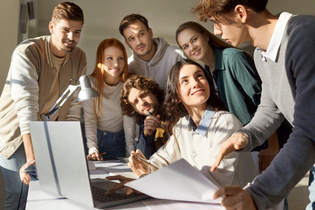 Diverse team of coworkers working together during a meeting in the office, using a laptop for business accounting. Teamwork, financial management, and the importance of collaboration.の写真素材