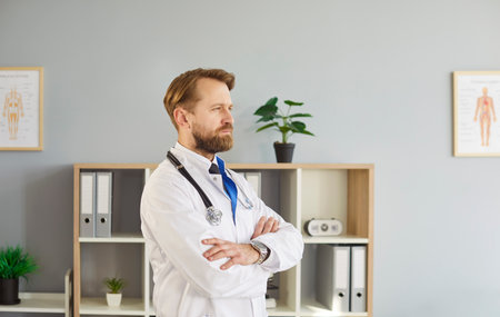Doctor in medical office wearing white lab coat and stethoscope, posing, looking thoughtfully to show professionalism calmness, expertise and contemplation within medical job, medical professionalの写真素材