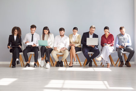 Diverse job candidates, people sitting in office hall on chairs in row, businesspeople waiting for job interview, human resources, employment and recruitment, candidates looking for hiring, hr choiceの写真素材