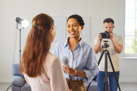 Professional woman journalist recording interview, holding microphone and asking questions, making content, using professional equipment, standing and talking. TV show and mass media conceptの写真素材
