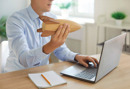 Executive manager launching toy rocket up in office, successful young businessman thinking about new project ideas, campaign, seek, planning, develop business model, motivation, sure in resultの写真素材