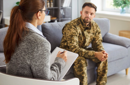 Psychologist offers therapy to veteran in office, providing doctor support and treatment, enhancing...